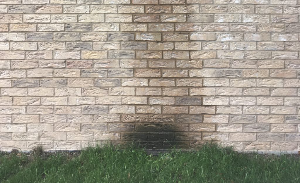 Water is overflowing from the gutter as causing foundation damage
